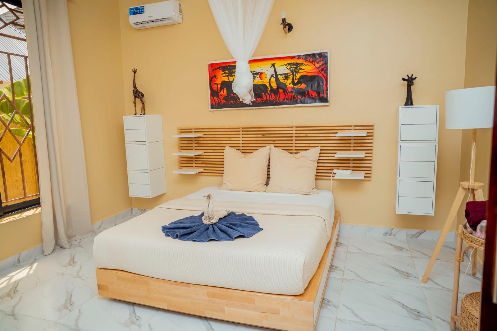 Chambre de la villa aux inspirations safari, toile de savane africaine au-dessus du lit à Kiwengwa